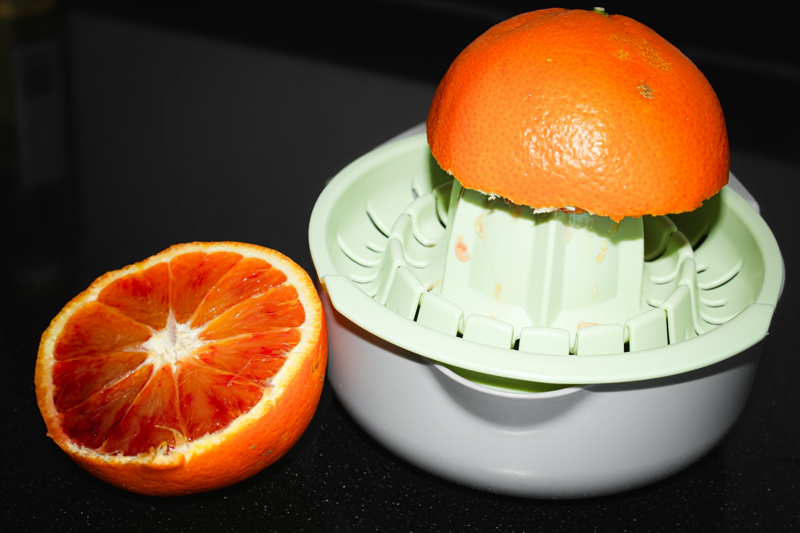 Juicing an orange with a citrus juicer.